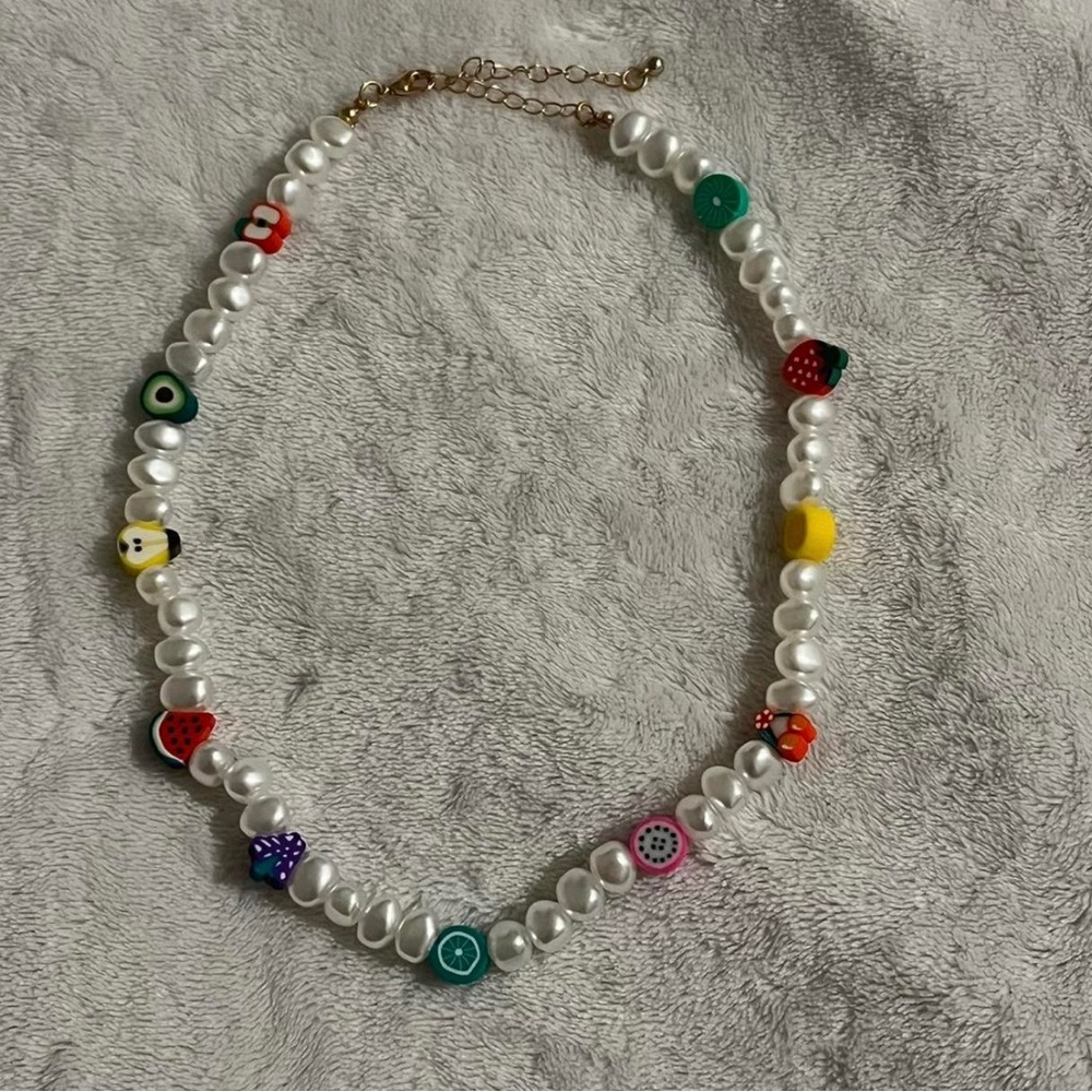 pearl necklace. chunky with fruit chunks along it. light weight. has a clasp.